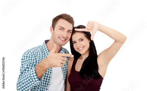 Playful couple fooling in dating day. Beautiful young lovers are joining and smiling, making frame from their hands isolated on white background