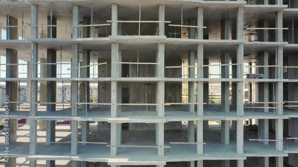 Aerial view of high residential apartment building under construction. Many windows on new apartment building facade under construction. Real estate development Aerial view of high residential apartment building under construction. Many windows on new apartment building facade under construction. Real estate development