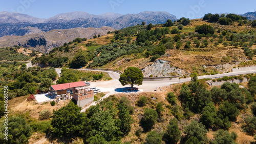 A lonely tree with a very nice panoramic view over the landscapes of Crete in drone view