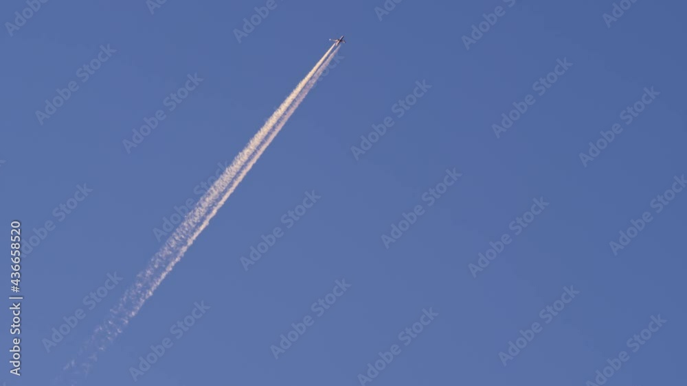 Jet airplane flying overhead in the clear blue sky and leaving behind a nice contrail track. Static shot. Jet airplane flying overhead in the clear blue sky and leaving behind a nice contrail track. Static shot.