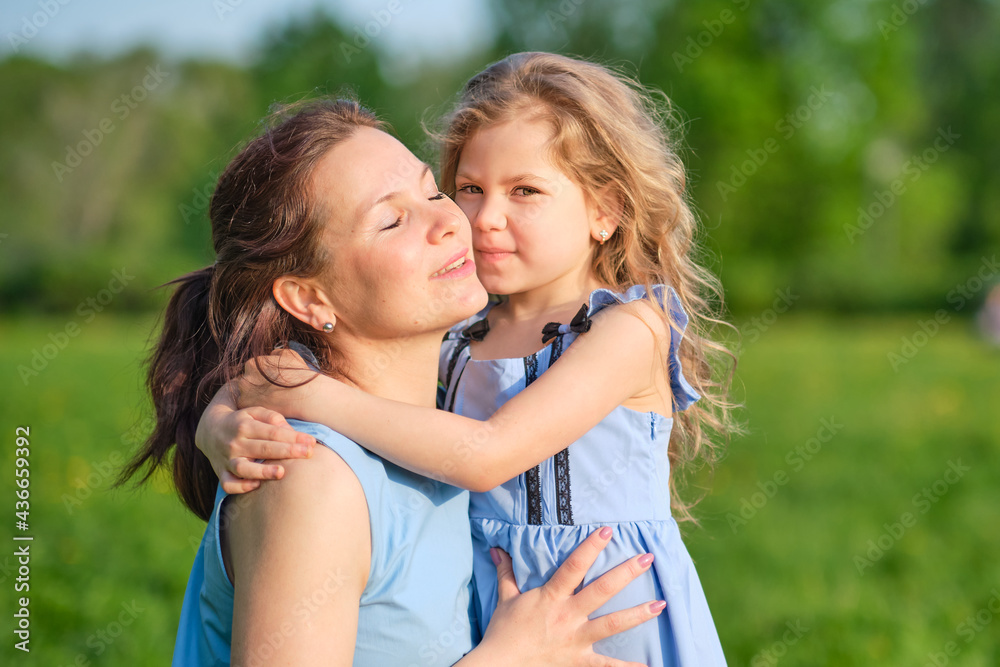 nature scene with family outdoor lifestyle. Mother and little daughter playing together in a park. Happy family concept. Happiness and harmony in family life.