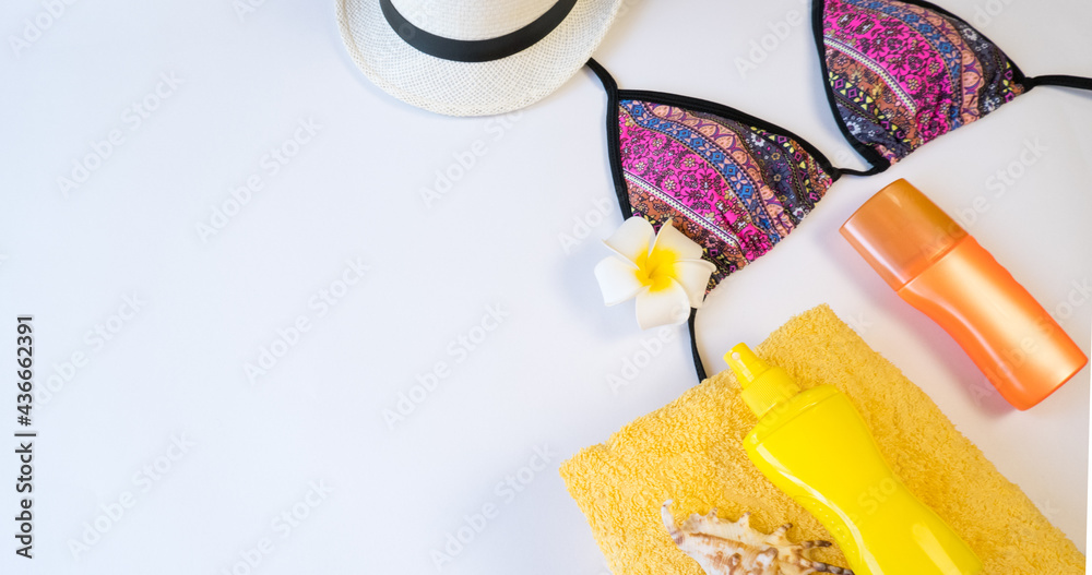 Flat lay with beach accessories on white paper background, place for text.