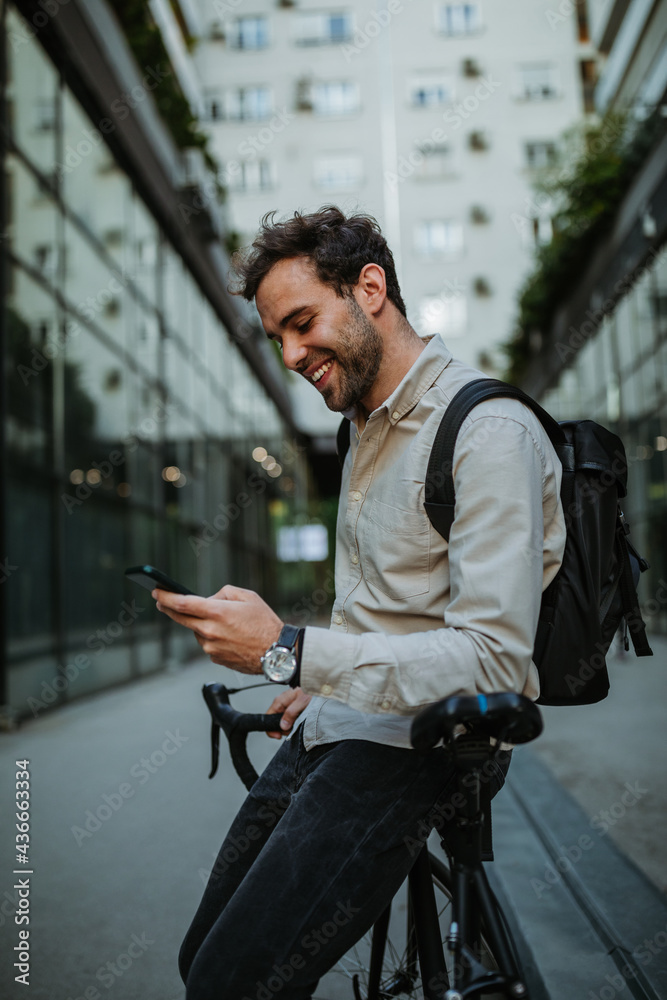 Man using a cellphone while walking with his bicycle in the city Man using a cellphone while walking with his bicycle in the city