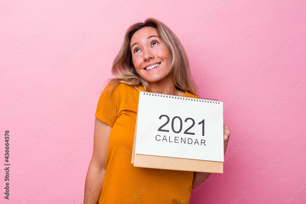 Young australian woman holding a calendar isolated on pink background dreaming of achieving goals and purposes Young australian woman holding a calendar isolated on pink background dreaming of achieving goals and purposes