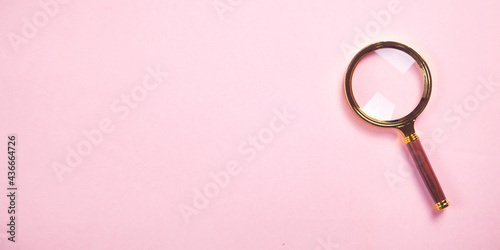 Magnifying glass on the pink background.