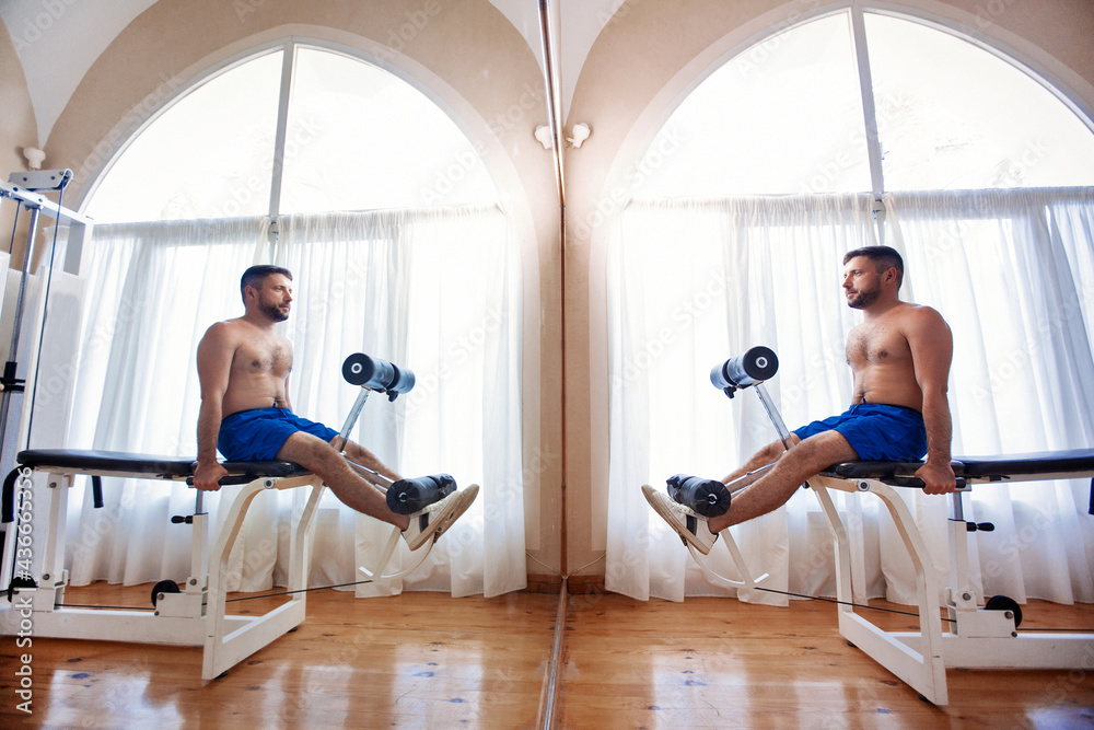 Happy man in the gym in the mirror image Happy man in the gym in the mirror image
