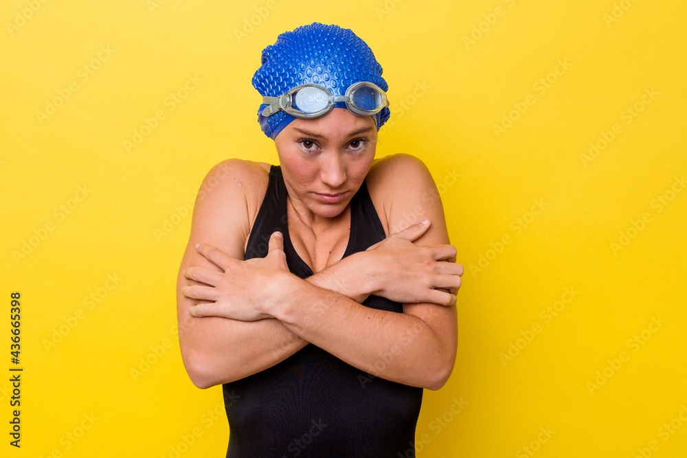 Young australian swimmer woman isolated on yellow background going cold due to low temperature or a sickness. Young australian swimmer woman isolated on yellow background going cold due to low temperature or a sickness.
