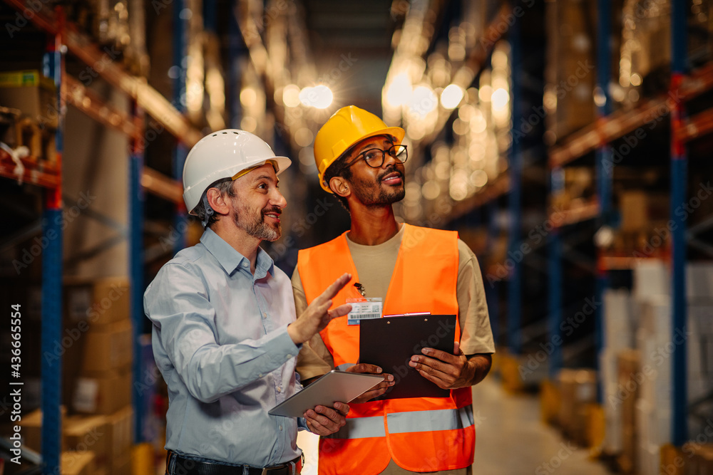 Businesspeople discussing about work in warehouse Businesspeople discussing about work in warehouse