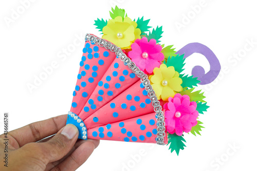 A crafted handmade umbrella made for small children held-ed by a person with his hand