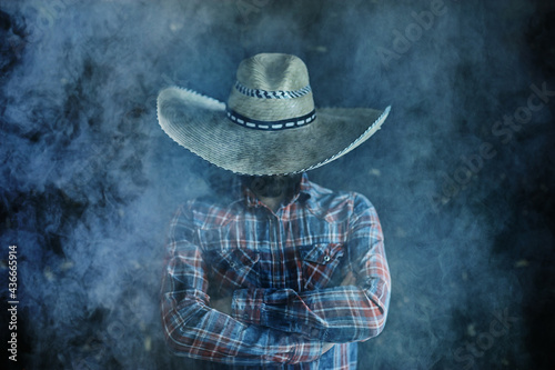 farmer hipster in a straw hat with brim in smoke smoking tobacco retro style wild west sambrero photo