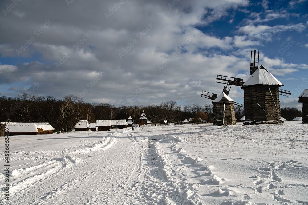 Seasonal Winter landscape with windmills under blue skies