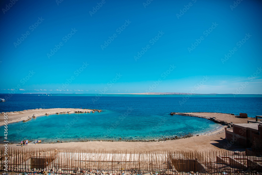 Fototapeta premium View of coast of Hurghada and ship in sea. Seafront Hurghada. View of Egyptian city of Hurghada from Red sea.