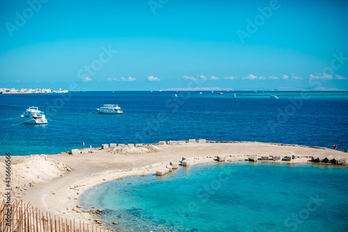 Fototapeta Naklejka Na Ścianę i Meble -  
View of coast of Hurghada and ship in sea. Seafront Hurghada. View of Egyptian city of Hurghada from Red sea.