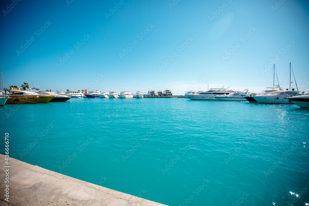 Marine parking of beautiful boats and yachts on clear calm water in Egypt. Travel and tourism concept.