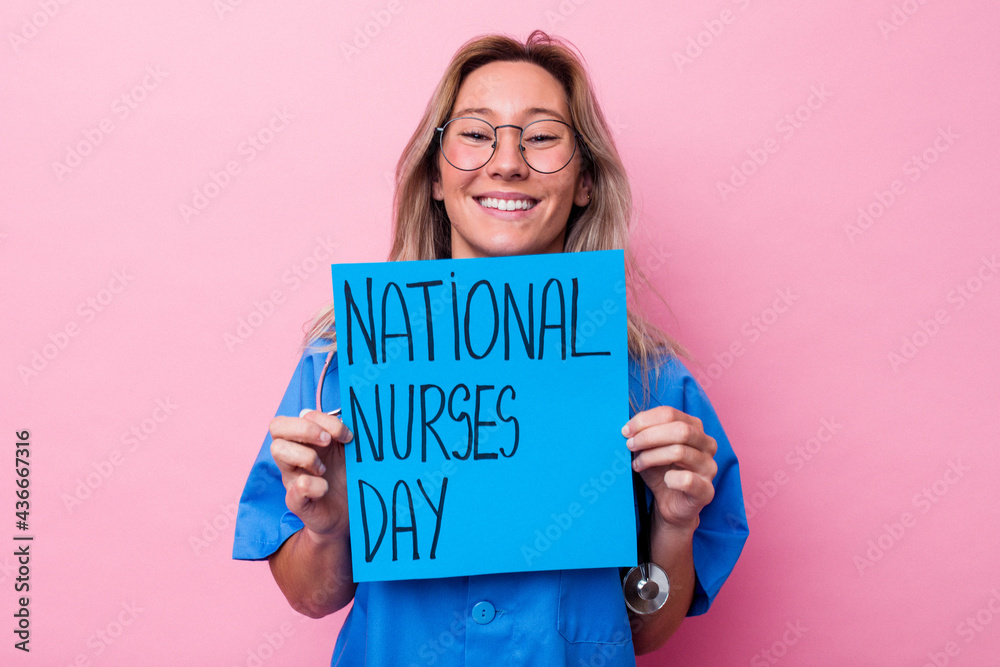 Young australian nurse woman holding a international nurses day placard isolated on blue background Young australian nurse woman holding a international nurses day placard isolated on blue background