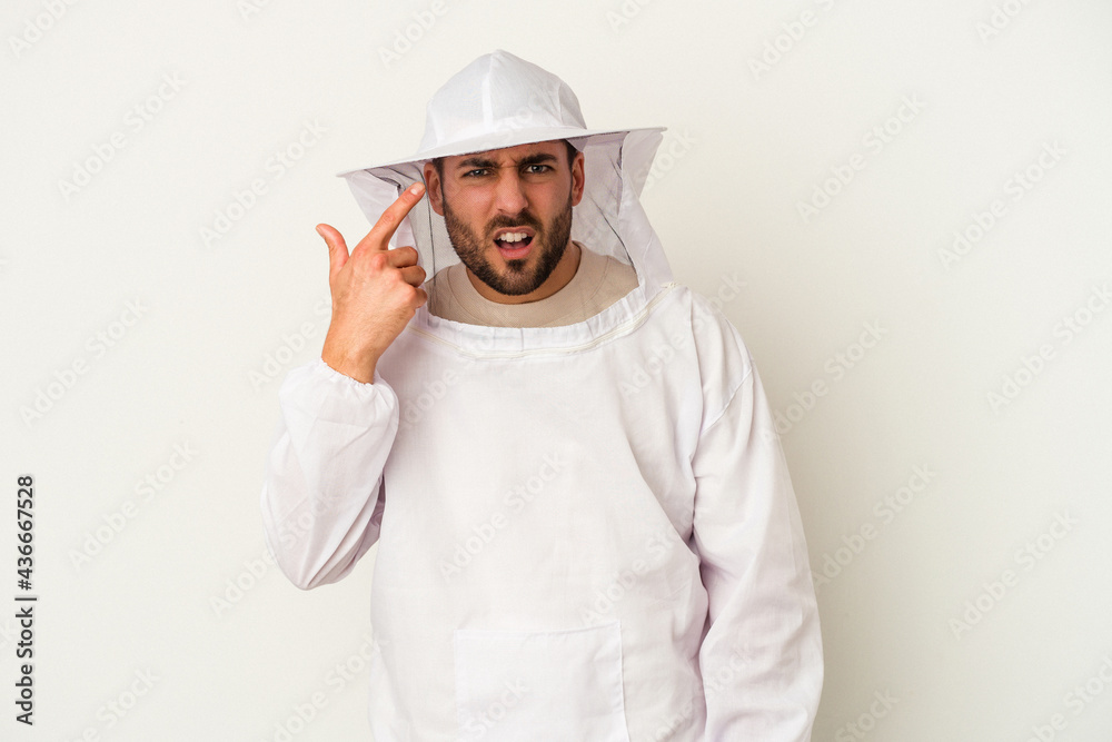 Young apiculture caucasian man isolated on white background showing a disappointment gesture with forefinger.