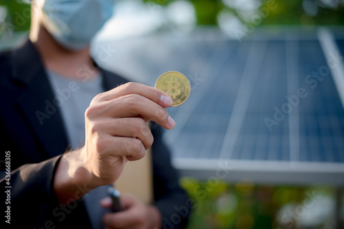businessman's hand is holding the Bitcoin coin..Bitcoin concept Bitcoin and renewable energy