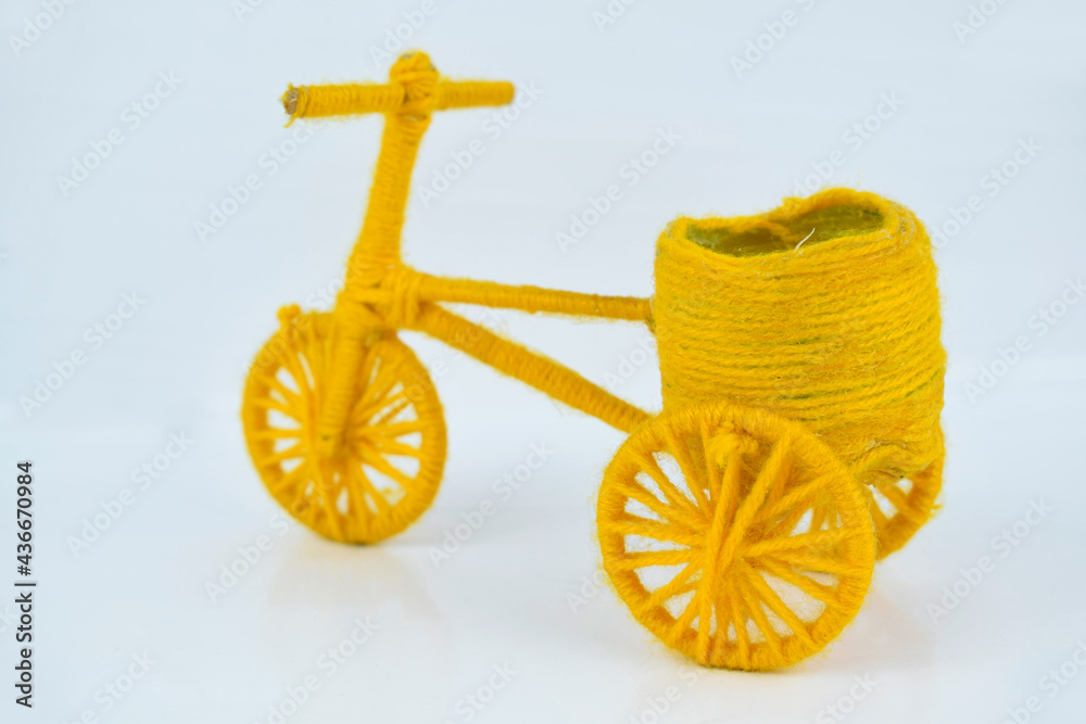 Beautiful yellow colored three wheeled miniature cycle with a big basket in the back