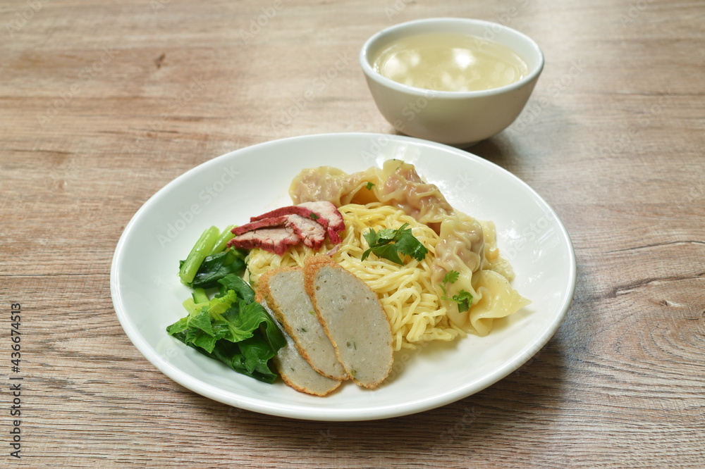 Chinese egg yellow noodles with barbecue pork and dumpling on plate with soup cup Chinese egg yellow noodles with barbecue pork and dumpling on plate with soup cup