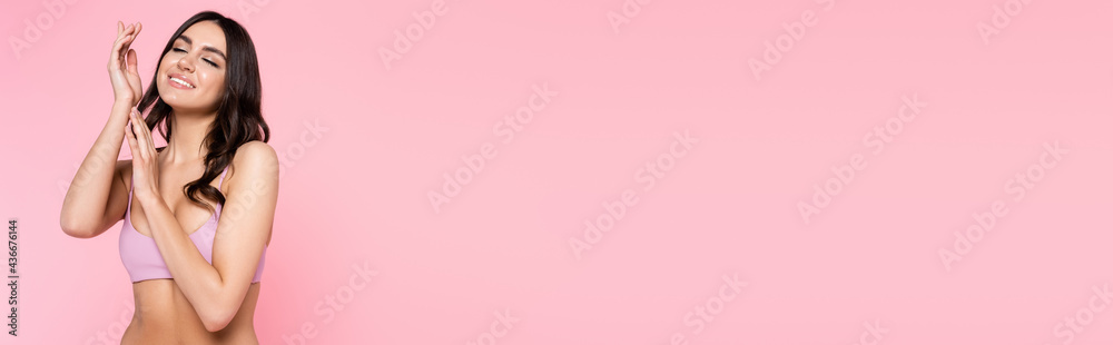 Smiling brunette woman in top of swimsuit isolated on pink, banner. Smiling brunette woman in top of swimsuit isolated on pink, banner.
