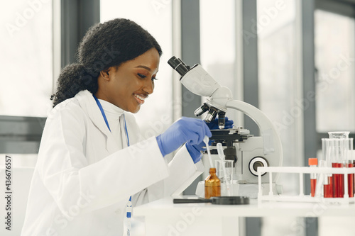 Female Scientist Working in The Laboratory Using a Microscope photo