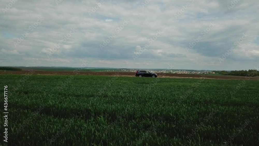 Aerial view. Drone follows after the car. Extreme Automobile driving on the field with grass. Off-road vehicle. Aerial view. Drone follows after the car. Extreme Automobile driving on the field with grass. Off-road vehicle.