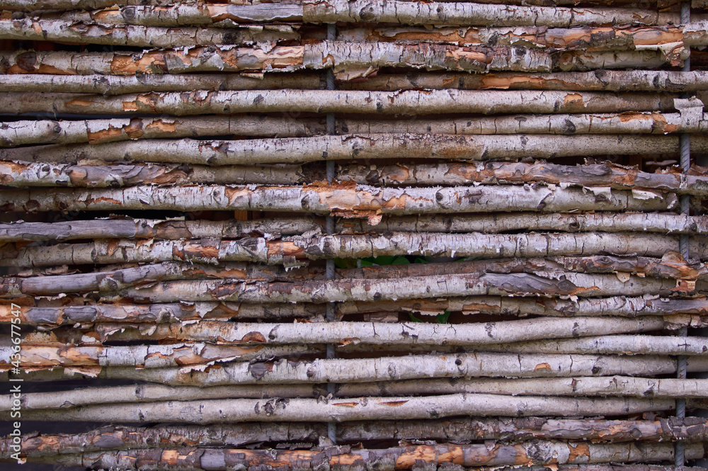 Natural fence of thin wooden twigs and willow branches