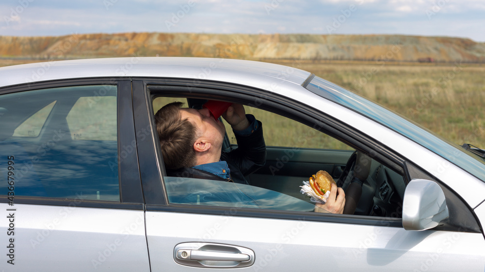 The manager eats lunch at  wheel in the car.