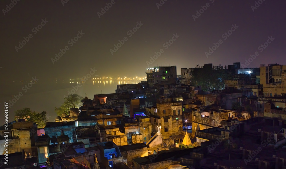 Fototapeta premium Historical indian city Varanasi, view over rooftop of the poor brick buildings, India. Banaras cityscape during night time