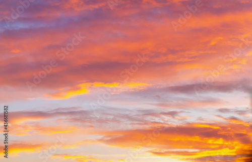 Soft  airy sky in the evening with feathery clouds in orange and blue shades