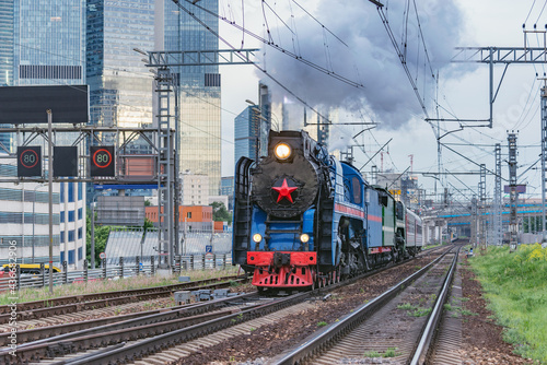 Retro steam train on Moscow city background.
