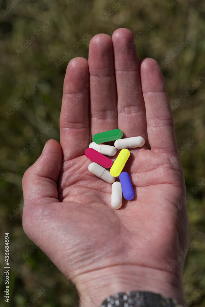 Own hand holding colorful pills at sunlight. Own hand holding colorful pills at sunlight.