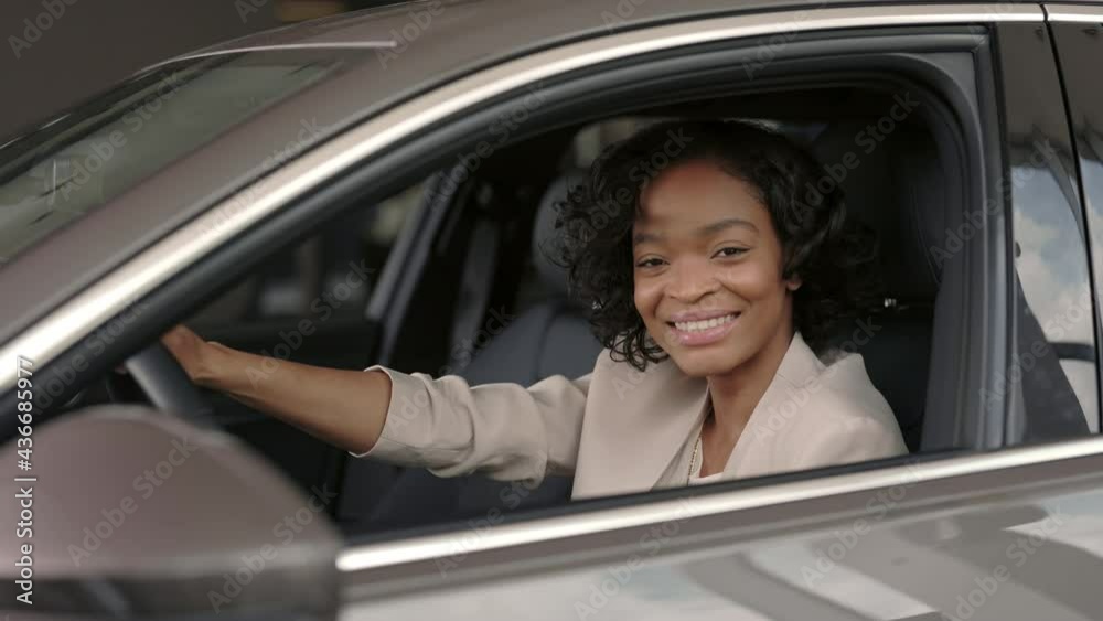 Smiling african lady examining salon of new car Smiling african lady examining salon of new car