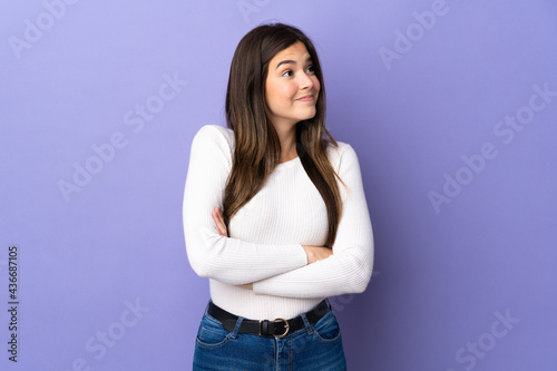 Teenager Brazilian girl over isolated purple background making doubts gesture while lifting the shoulders