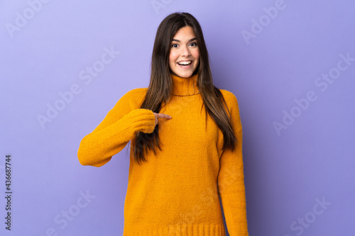 Teenager Brazilian girl over isolated purple background with surprise facial expression © luismolinero