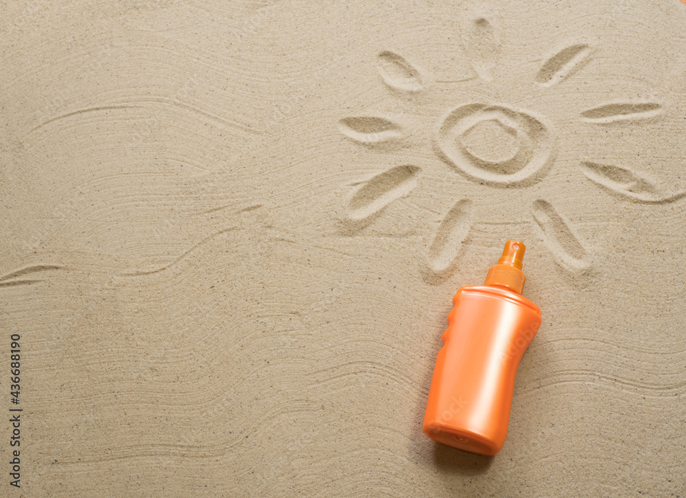 Sand texture with painted sun and orange sunscreen tube. Empty space for creative design or text. Relax on the sandy beach. Holidays and travel concept Sand texture with painted sun and orange sunscreen tube. Empty space for creative design or text. Relax on the sandy beach. Holidays and travel concept