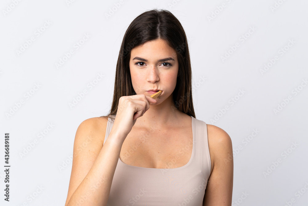 Teenager Brazilian girl brushing her teeth over isolated white background Teenager Brazilian girl brushing her teeth over isolated white background