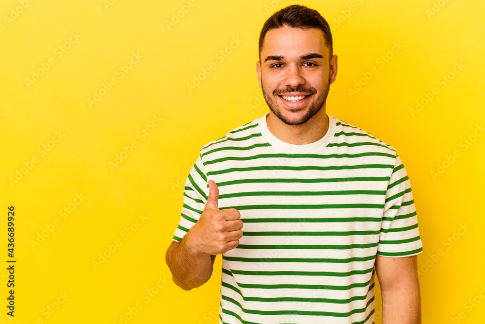 Young caucasian man isolated on yellow background smiling and raising thumb up Young caucasian man isolated on yellow background smiling and raising thumb up