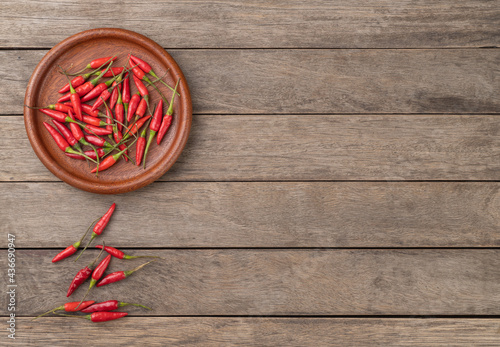 Red malagueta peppers on a plate over wooden table with copy space photo