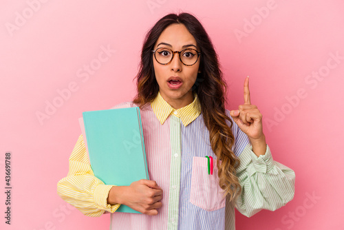Young student mexican woman isolated on pink background having an idea, inspiration concept.
