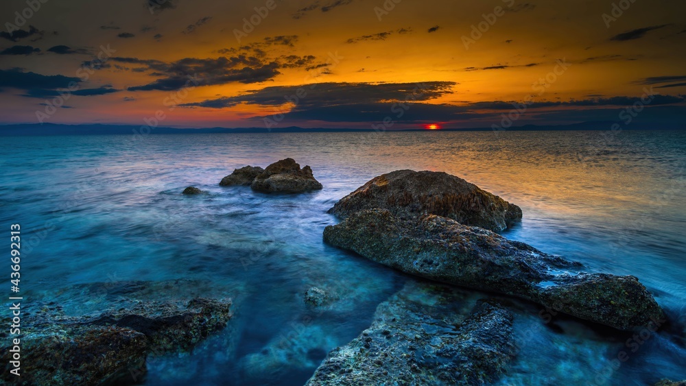 Skały na wybrzeżu morza Adriatyckiego w Grecji o wschodzie słońca - obrazy, fototapety, plakaty 