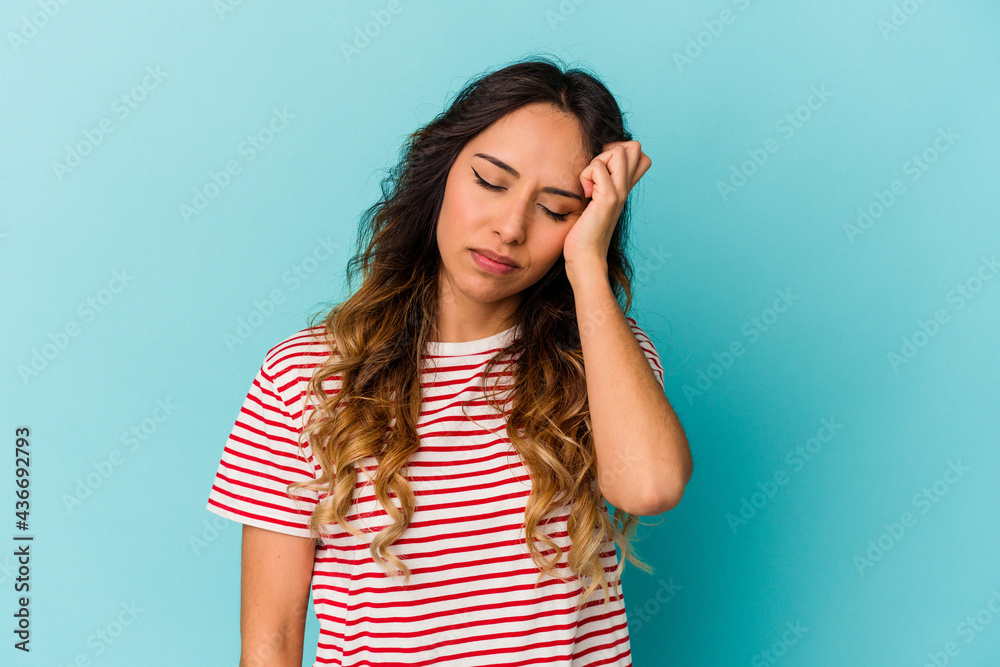 Young mexican woman isolated on blue background tired and very sleepy keeping hand on head. Young mexican woman isolated on blue background tired and very sleepy keeping hand on head.