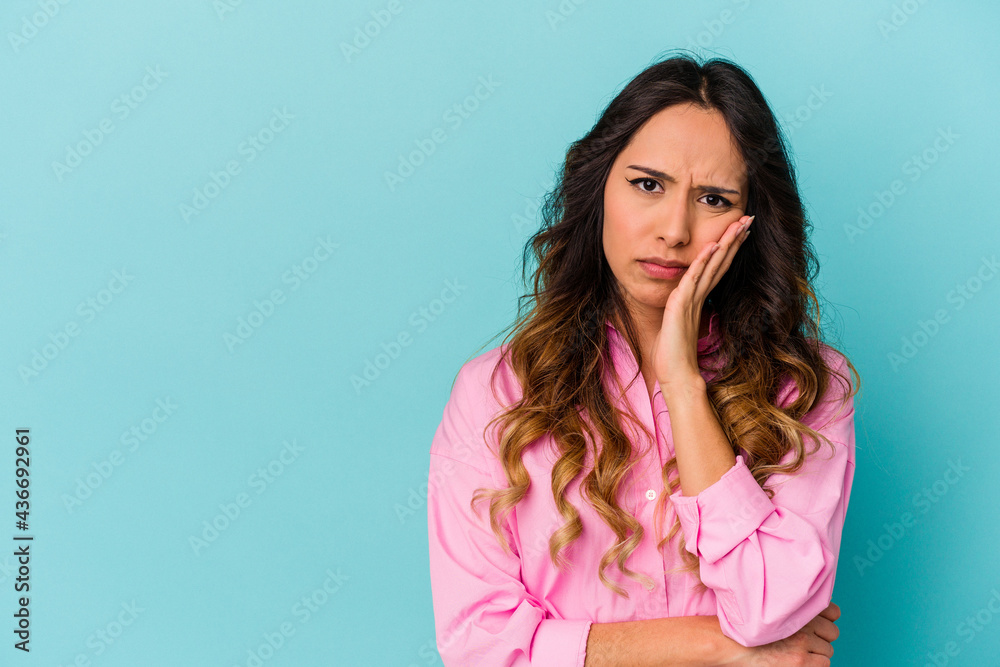 Young mexican woman isolated on blue background who feels sad and pensive, looking at copy space.