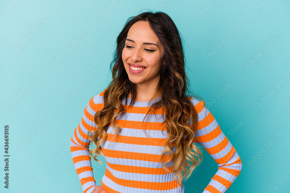 Fototapeta premium Young mexican woman isolated on blue background confident keeping hands on hips.