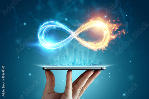 Infinity sign over smartphone, Fire ice sign on blue background photo
