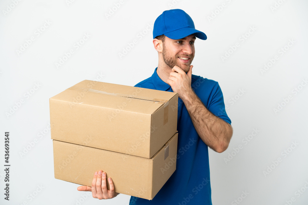 Delivery man over isolated white background looking to the side and smiling Delivery man over isolated white background looking to the side and smiling