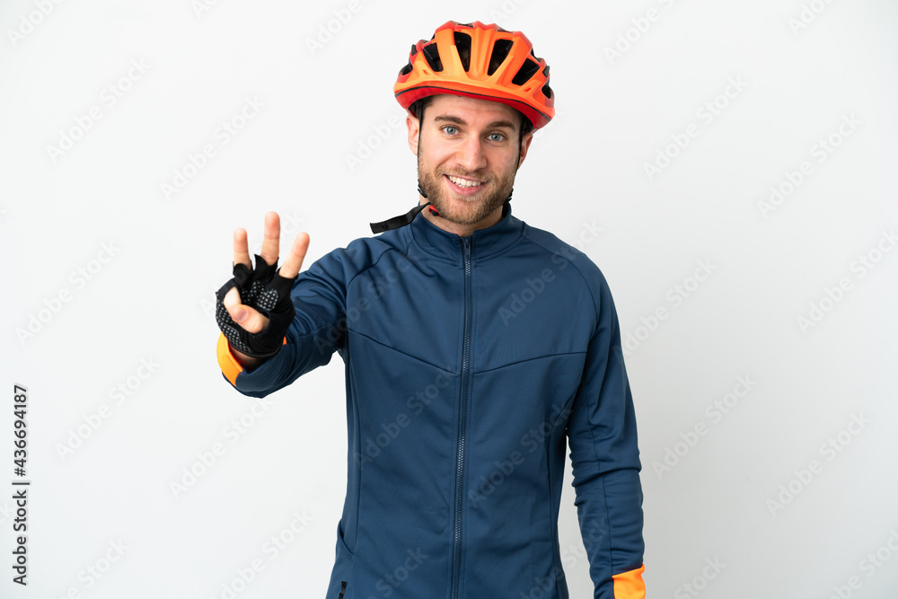 Young cyclist man isolated on white background happy and counting three with fingers