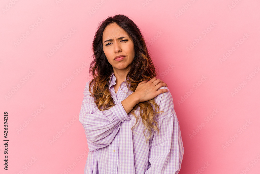 Young mexican woman isolated on pink background having a shoulder pain. Young mexican woman isolated on pink background having a shoulder pain.