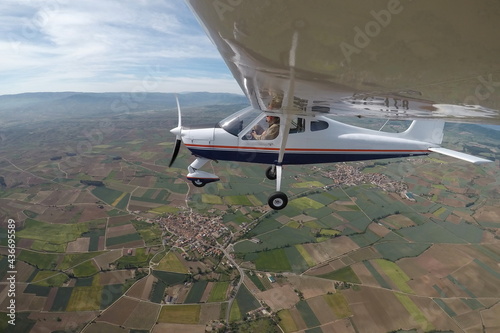 PILOT IN A SINGLE-ENGINE AIRPLANE WITH A HIGH WING FLYING OVER THE VILLAGES OF AZOFRA AND ALESANCO SURROUNDED BY CROP FIELDS IN THE PROVINCE OF LA RIOJA photo