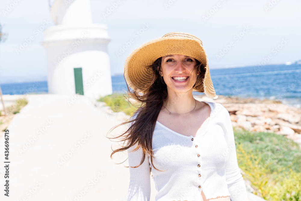 caucasian girl with straw hat smiling at camera